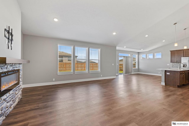 7530 Augustine Ave, Lincoln, NE 68516 - unfurnished living room with lofted ceiling, a fireplace, dark wood finished floors, and recessed lighting