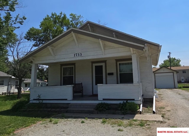 1733 Market St, Beatrice, NE 68310 - view of front of house with covered porch, dirt driveway, an outbuilding, and a garage