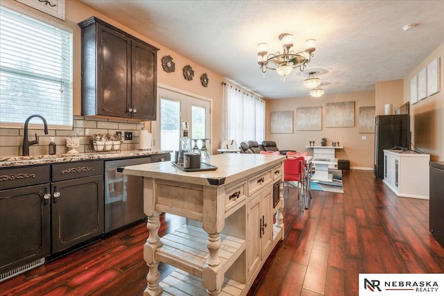 16228 Virginia St, Omaha, NE 68136 - kitchen featuring stainless steel dishwasher, a chandelier, dark wood-type flooring, backsplash, and dark brown cabinetry