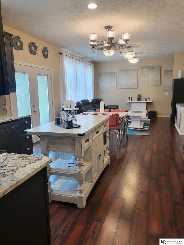 16228 Virginia St, Omaha, NE 68136 - kitchen with freestanding refrigerator, dark wood-style flooring, a textured ceiling, a chandelier, and light stone countertops