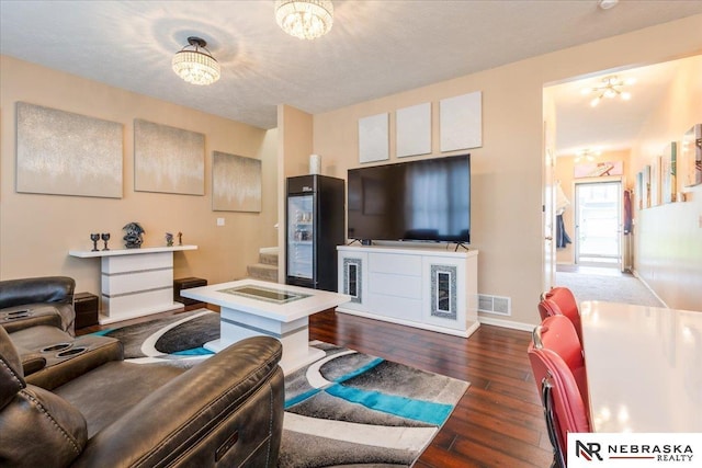 16228 Virginia St, Omaha, NE 68136 - living room with dark wood-style flooring, a chandelier, and a textured ceiling