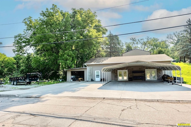 817 S 3rd St, Nebraska City, NE 68410 - garage featuring french doors, driveway, and view of wooded area