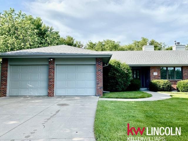 2930 Drawbridge Ct, Lincoln, NE 68516 - ranch-style home with a garage, brick siding, a chimney, a front yard, and concrete driveway