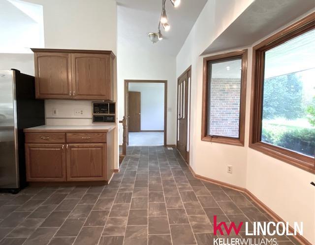 2930 Drawbridge Ct, Lincoln, NE 68516 - kitchen featuring freestanding refrigerator and light countertops