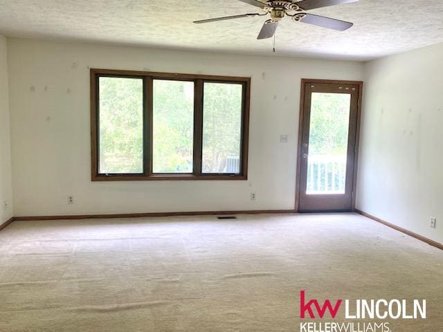 2930 Drawbridge Ct, Lincoln, NE 68516 - spare room with carpet floors, a textured ceiling, and a ceiling fan