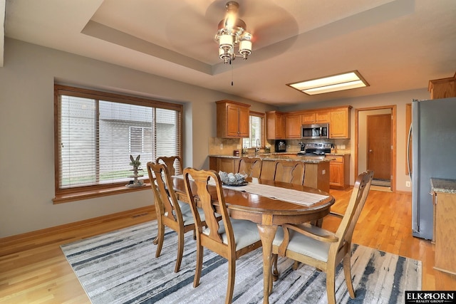 19523 Binney Cir, Elkhorn, NE 68022 - dining area featuring ceiling fan, light wood-style floors, a raised ceiling, and a baseboard radiator