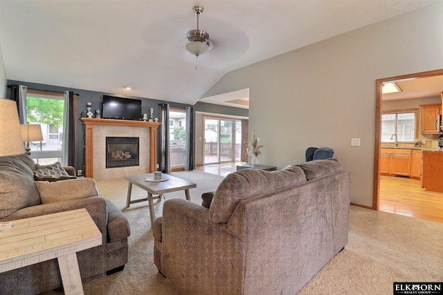 19523 Binney Cir, Elkhorn, NE 68022 - living room featuring ceiling fan, plenty of natural light, a fireplace, vaulted ceiling, and light carpet