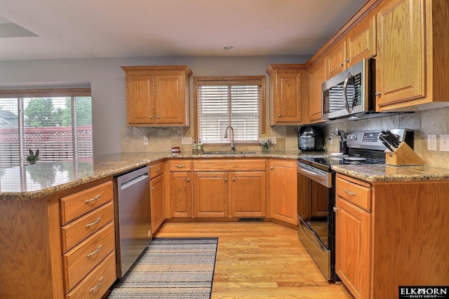 19523 Binney Cir, Elkhorn, NE 68022 - kitchen with appliances with stainless steel finishes, light wood finished floors, plenty of natural light, and a peninsula