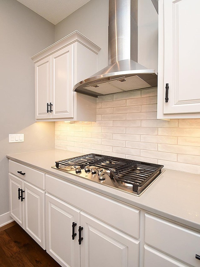 10309 S 102nd St, Papillion, NE 68046 - kitchen featuring wall chimney exhaust hood, stainless steel gas cooktop, white cabinetry, and decorative backsplash