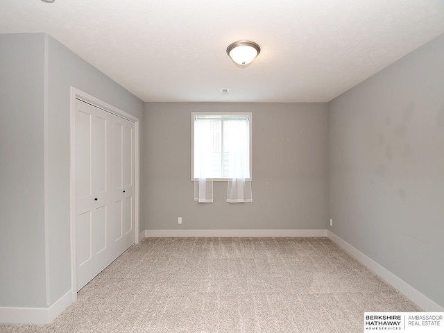 10309 S 102nd St, Papillion, NE 68046 - unfurnished bedroom featuring light carpet, a closet, and a textured ceiling