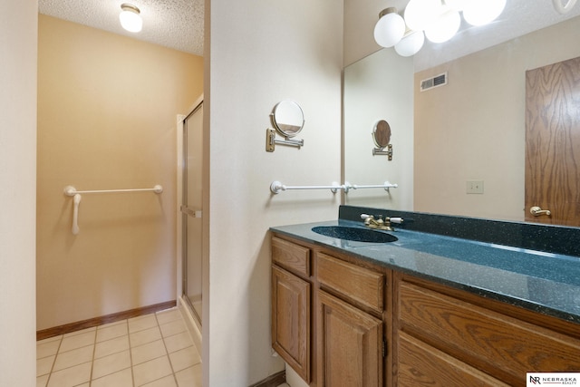 11937 Miracle Hills Dr Unit 11, Omaha, NE 68154 - bathroom with a stall shower, vanity, a textured ceiling, and tile patterned floors