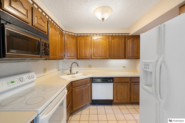 11937 Miracle Hills Dr Unit 11, Omaha, NE 68154 - kitchen featuring white appliances, a textured ceiling, brown cabinets, light countertops, and light tile patterned flooring