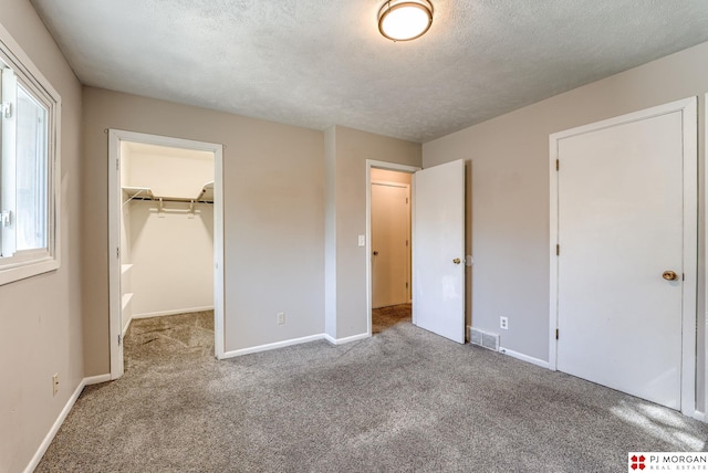 2811 S 36th St, Omaha, NE 68105 - unfurnished bedroom featuring carpet, a walk in closet, a textured ceiling, and a closet