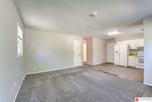 2811 S 36th St, Omaha, NE 68105 - unfurnished living room featuring light colored carpet and a textured ceiling