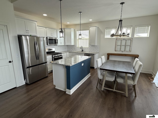 2308 Alexandra Rd, Papillion, NE 68133 - kitchen with appliances with stainless steel finishes, decorative backsplash, white cabinets, a chandelier, and dark wood finished floors