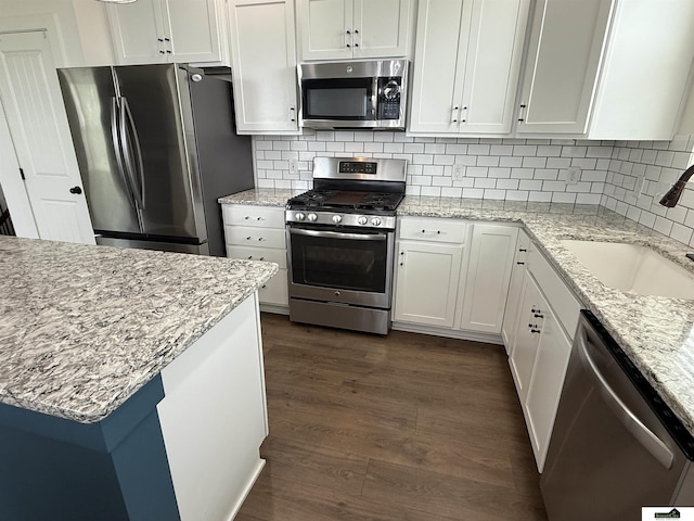 2308 Alexandra Rd, Papillion, NE 68133 - kitchen featuring appliances with stainless steel finishes, dark wood-type flooring, white cabinetry, and decorative backsplash