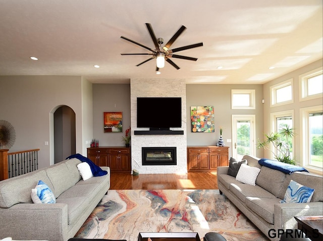 1526 Provencal Cir, Yutan, NE 68073 - living area with wood finished floors, arched walkways, a fireplace, a ceiling fan, and recessed lighting