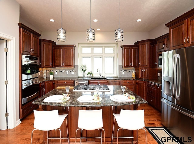 1526 Provencal Cir, Yutan, NE 68073 - kitchen featuring stainless steel appliances, backsplash, a kitchen bar, a center island, and recessed lighting