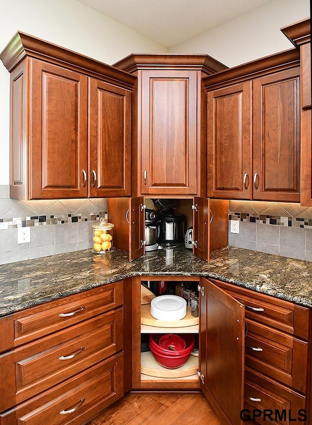 1526 Provencal Cir, Yutan, NE 68073 - kitchen featuring tasteful backsplash, light wood-style flooring, dark stone counters, and brown cabinets