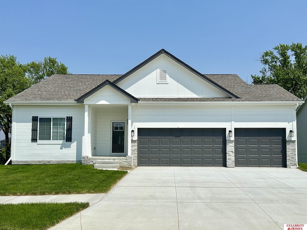 11859 S 105th Ave, Papillion, NE 68046 - view of front of property featuring a garage, driveway, a front yard, and a shingled roof