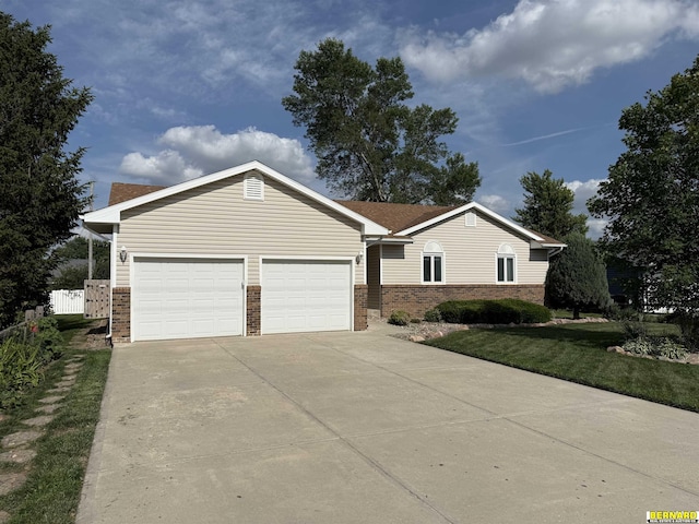 304 Broadway St, Manley, NE 68403 - single story home with brick siding, concrete driveway, an attached garage, and a front lawn