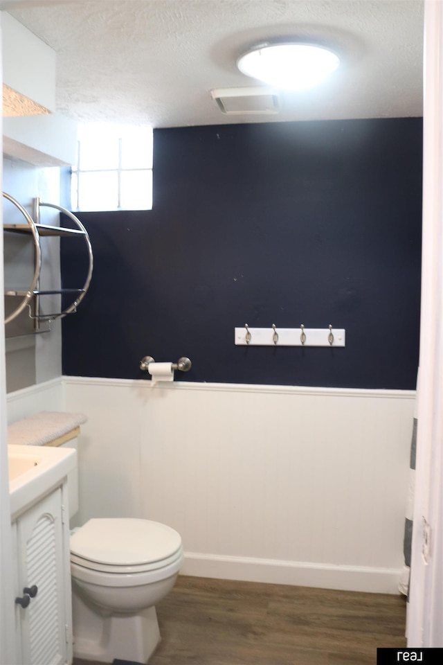 1912 Freeman Dr, Bellevue, NE 68005 - half bathroom with a textured ceiling, vanity, a wainscoted wall, and wood finished floors