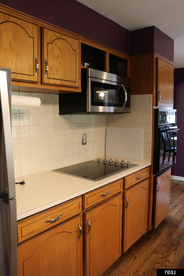 1912 Freeman Dr, Bellevue, NE 68005 - kitchen featuring black appliances, dark wood-style floors, light countertops, backsplash, and brown cabinets