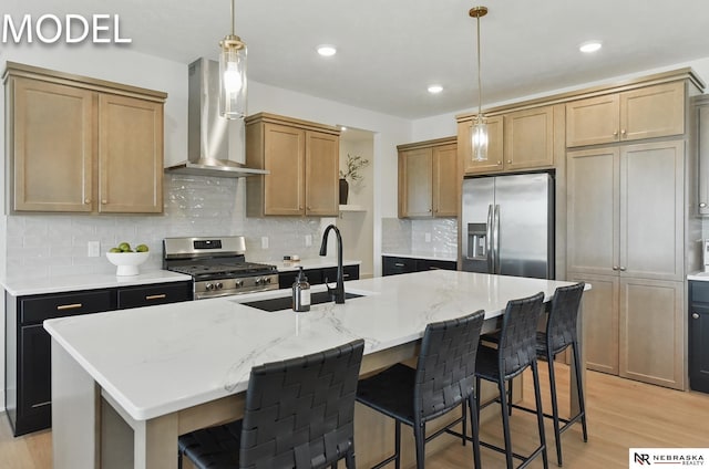 12386 Fenwick St, Papillion, NE 68046 - kitchen with stainless steel appliances, wall chimney exhaust hood, light wood finished floors, a breakfast bar, and a kitchen island with sink