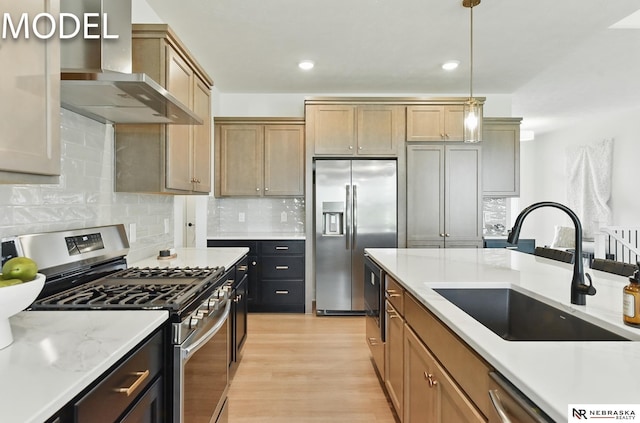 12386 Fenwick St, Papillion, NE 68046 - kitchen featuring appliances with stainless steel finishes, wall chimney range hood, hanging light fixtures, light wood-type flooring, and tasteful backsplash