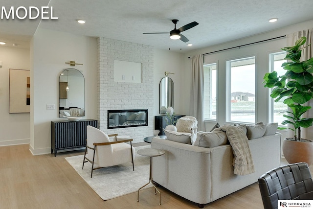 12386 Fenwick St, Papillion, NE 68046 - living area with ceiling fan, light wood-style floors, and a brick fireplace