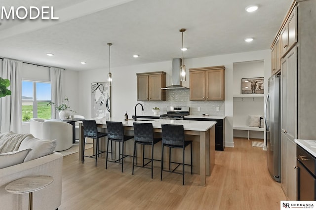 12386 Fenwick St, Papillion, NE 68046 - kitchen featuring wall chimney range hood, stainless steel appliances, light wood-style floors, backsplash, and open floor plan