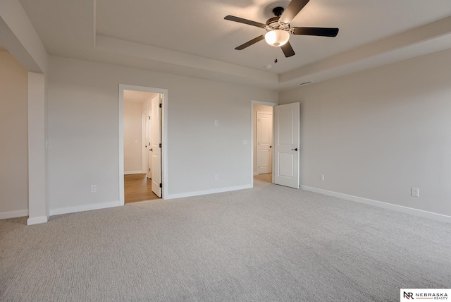 12382 Fenwick St, Papillion, NE 68046 - spare room with a tray ceiling, light colored carpet, and ceiling fan