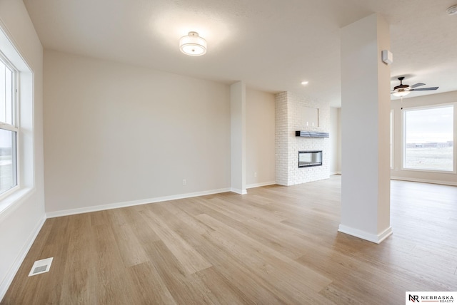 12382 Fenwick St, Papillion, NE 68046 - unfurnished living room featuring light wood-style flooring, ceiling fan, and a large fireplace