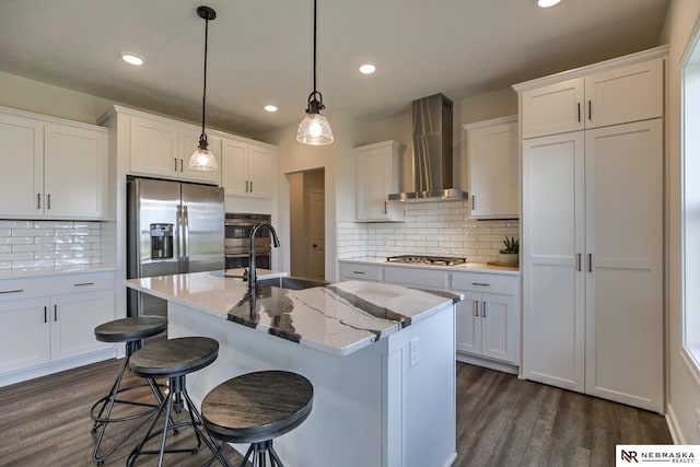 19015 Ranch Dr, Papillion, NE 68046 - kitchen with wall chimney range hood, dark wood-style floors, appliances with stainless steel finishes, backsplash, and white cabinets