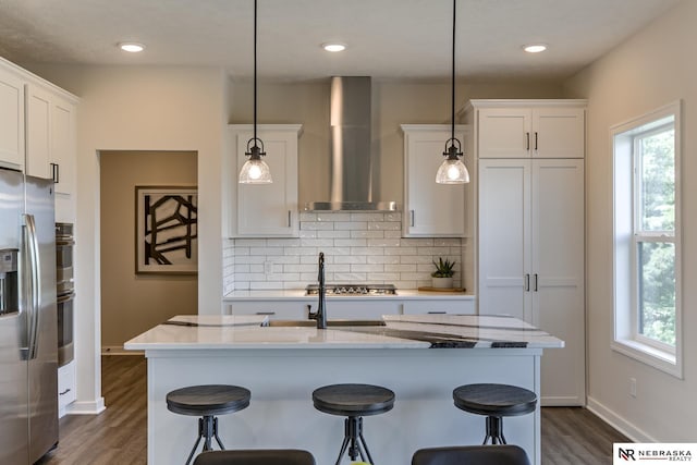 19015 Ranch Dr, Papillion, NE 68046 - kitchen featuring wall chimney range hood, appliances with stainless steel finishes, plenty of natural light, dark wood-style floors, and recessed lighting