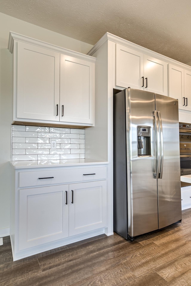 19015 Ranch Dr, Papillion, NE 68046 - kitchen featuring stainless steel fridge, dark wood-style flooring, white cabinets, and a textured ceiling