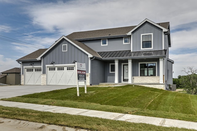 19015 Ranch Dr, Papillion, NE 68046 - view of front facade featuring board and batten siding, a standing seam roof, stone siding, a garage, and a porch