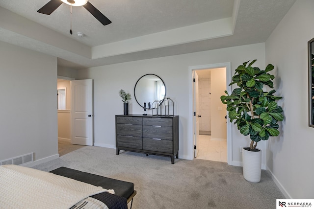 19015 Ranch Dr, Papillion, NE 68046 - carpeted bedroom with a tray ceiling, a textured ceiling, ensuite bath, and ceiling fan