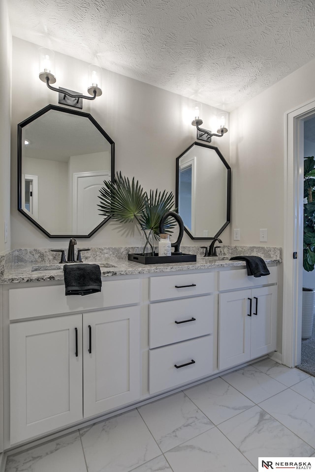 19015 Ranch Dr, Papillion, NE 68046 - full bathroom with marble look tiles, double vanity, and a textured ceiling