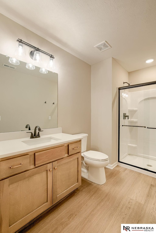12206 S 113th St, Papillion, NE 68046 - bathroom with wood finished floors, a stall shower, vanity, and a textured ceiling