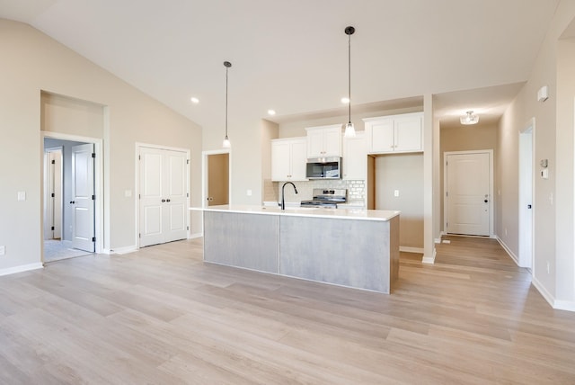 12206 S 113th St, Papillion, NE 68046 - kitchen with appliances with stainless steel finishes, vaulted ceiling, tasteful backsplash, light countertops, and white cabinets