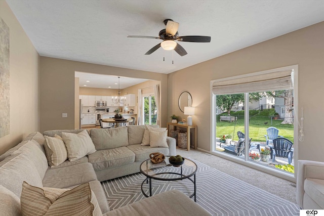 16454 Drexel St, Omaha, NE 68135 - living room featuring a ceiling fan, light colored carpet, and a chandelier