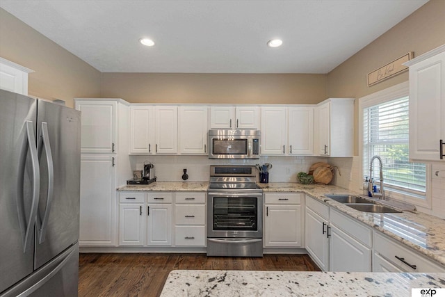 16454 Drexel St, Omaha, NE 68135 - kitchen featuring appliances with stainless steel finishes, white cabinetry, backsplash, dark wood-type flooring, and light stone counters