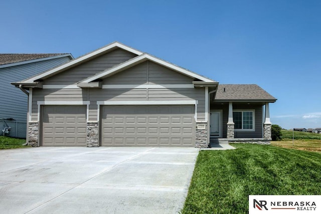 11152 Portage Dr, Papillion, NE 68046 - craftsman-style home featuring stone siding, an attached garage, driveway, and a front lawn