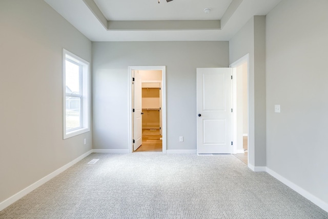 11152 Portage Dr, Papillion, NE 68046 - unfurnished bedroom featuring carpet, a walk in closet, a tray ceiling, and a closet