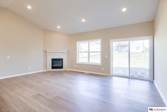 11152 Portage Dr, Papillion, NE 68046 - unfurnished living room with light wood-type flooring, lofted ceiling, a fireplace, and recessed lighting