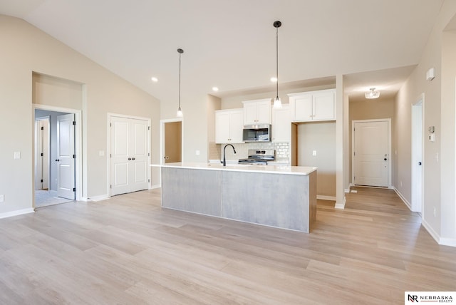 11152 Portage Dr, Papillion, NE 68046 - kitchen featuring stainless steel appliances, vaulted ceiling, light countertops, backsplash, and white cabinetry