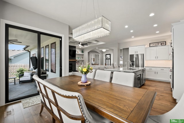 4802 N 187th Ave, Elkhorn, NE 68022 - dining area with recessed lighting, wood finished floors, arched walkways, a glass covered fireplace, and a ceiling fan