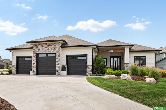 4802 N 187th Ave, Elkhorn, NE 68022 - prairie-style home with a garage, driveway, stone siding, roof with shingles, and a front yard