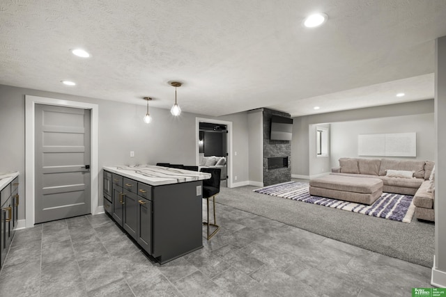 4802 N 187th Ave, Elkhorn, NE 68022 - kitchen featuring a kitchen breakfast bar, a fireplace, light countertops, recessed lighting, and open floor plan
